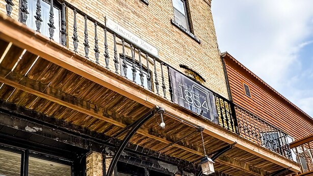 A brick building with large windows and a balcony. - American House 1854- Steamboat Landing, 4 Bedrooms, 1.5 Bath, Full Kitchen (McGregor)