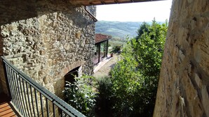 A stone building with a balcony overlooking a rural landscape. - Agriturismo Casa Greppo - Il Noce (San Venanzo)