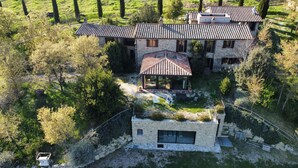 A large stone house with a tiled roof, surrounded by trees and a grassy field. - Agriturismo Casa Greppo - Il Noce (San Venanzo)