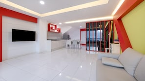 A modern living room with a flat-screen TV, a sofa, and a dining area with chairs.