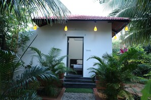 A small building with a tiled roof, a door, and steps leading up to it.