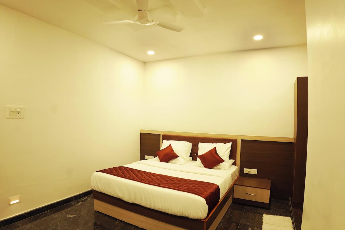 A neatly arranged hotel room with a bed, bedside table, and a wardrobe.
