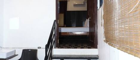 A staircase leading to a bedroom with a bed, a chair, and a small table.