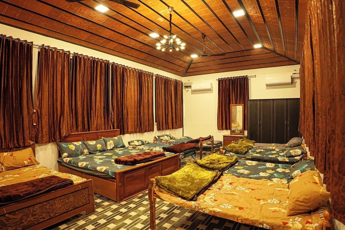 A cozy room with a large sofa set, a wooden ceiling, and a checkered floor.