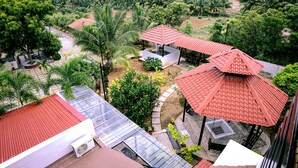 Terraço no terraço com telhados vermelhos, rodeado por vegetação exuberante e palmeiras.