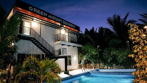 Um resort moderno com piscina e área de estar externa.