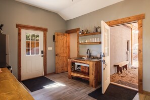 A kitchen with wooden cabinetry, a built-in sink, and a bench.