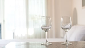 Two empty wine glasses on a table in a bright room with a blurred background.