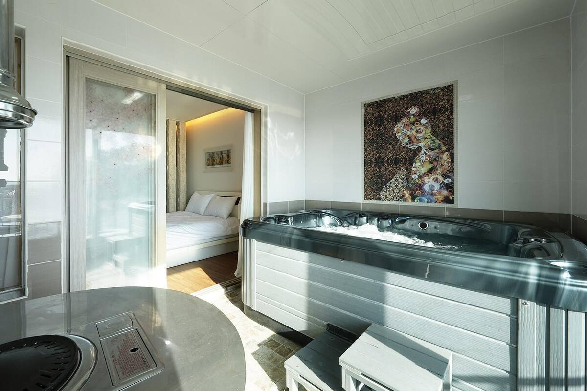A modern bathroom with a glass-enclosed shower, a large bathtub, and a toilet.