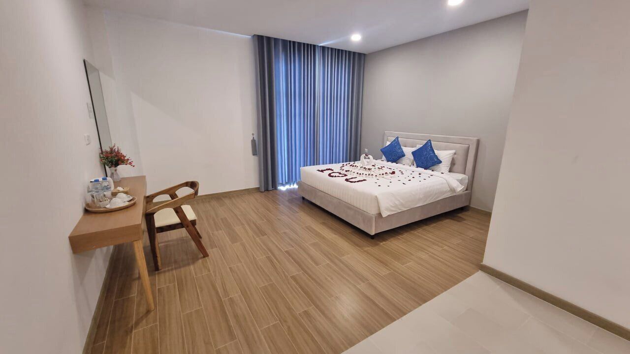 A modern bedroom with a bed, a desk, and a chair.