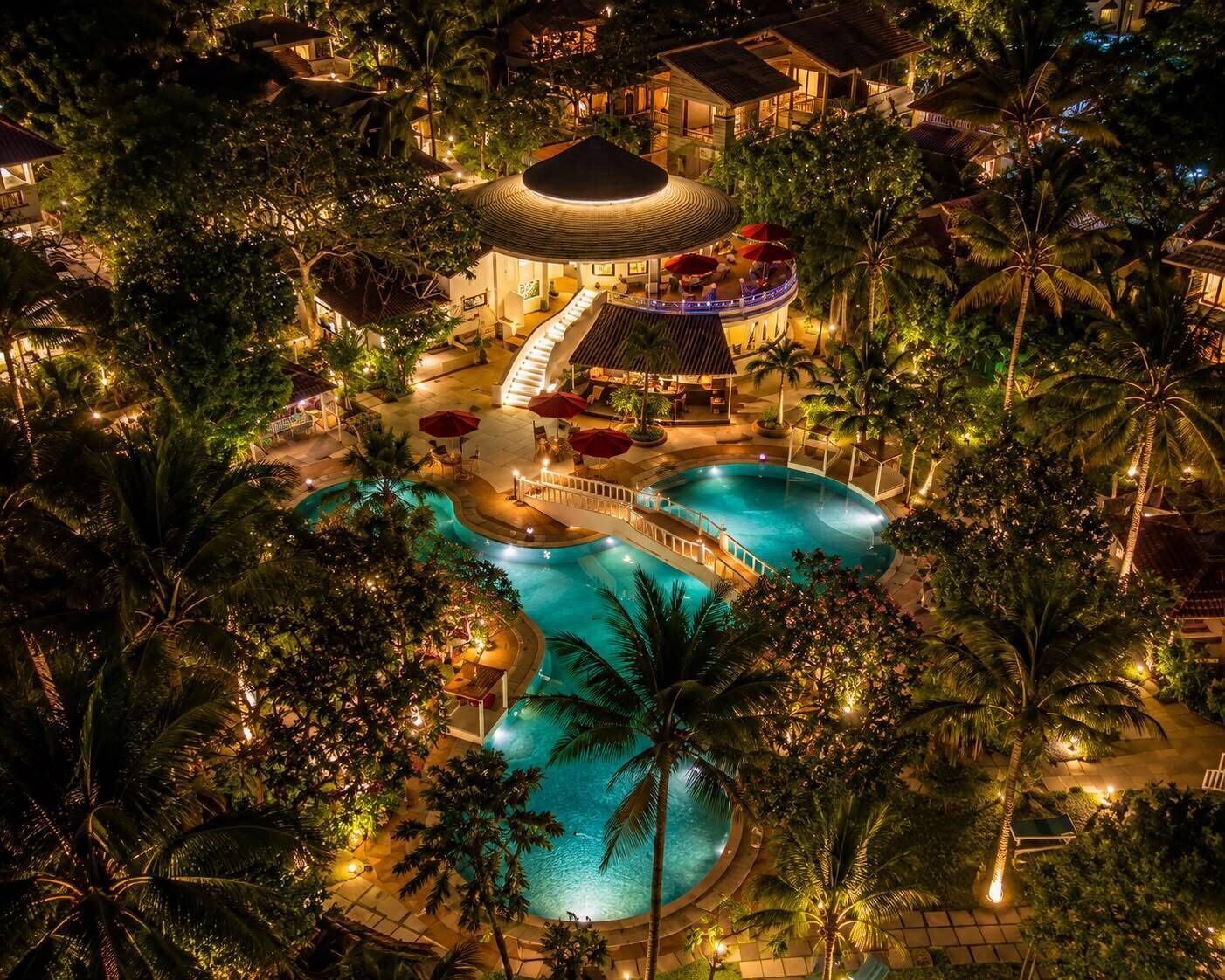 Resort com várias piscinas, um toboágua central e uma área coberta com assentos.