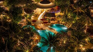 Resort com várias piscinas, um toboágua central e uma área coberta com assentos.