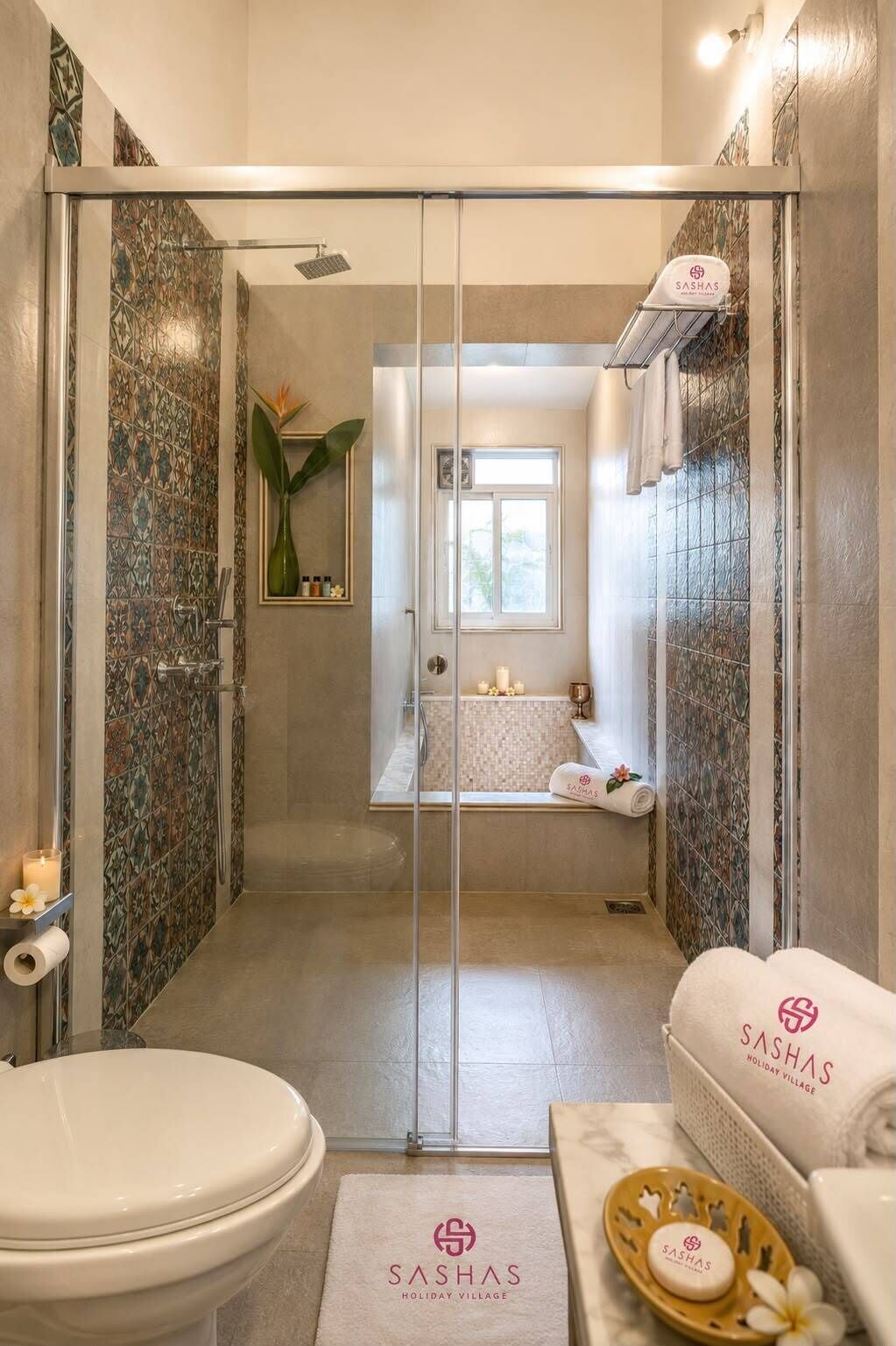 Un baño moderno con cabina de ducha de vidrio, inodoro, lavamanos y tocador con un plato para toallas y jabón.