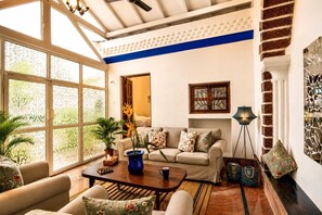 A well-lit living room with a sofa, coffee table, and decorative plants.