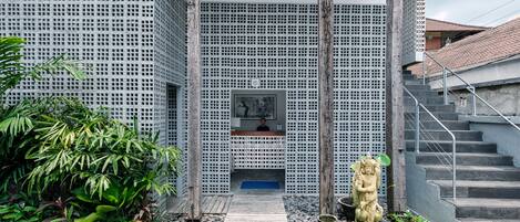 Un bâtiment moderne doté d’une terrasse en bois, d’une statue et d’un escalier.