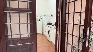 A kitchen with a washing machine, a refrigerator, and a sink.