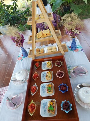 A wooden serving tray with various food items and a white teapot on a tablecloth. - Tung Na Pa Suan Farmstay (Doem Bang Nang Buat)