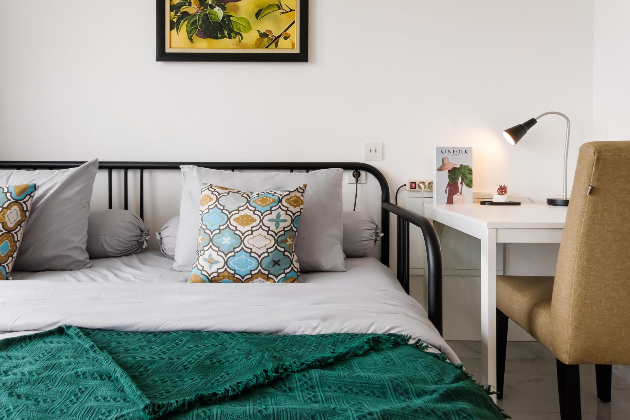 Quarto bem arrumado com uma cama, uma escrivaninha e uma cadeira.