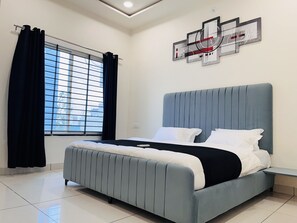 A modern bedroom with a large bed, a window with curtains, and a wall art piece.