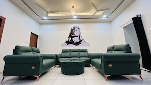 A modern living room with a sectional sofa, a coffee table, and a ceiling fan. - Home Escape Luxe (Ujjain)