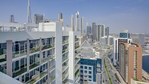 A high-rise building with multiple floors, large windows, and a modern architectural design. - Two Bed Room 5 minutes to Burj Khalifa & Dubai Mall-DAMAC REVA Residence 2705 (Dubai)
