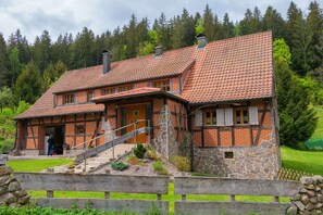 A traditional chalet with a steeply pitched roof, stone foundation, and wooden exterior. - Forsthaus | Grillplätze | Sauna | Zaun | Multifunktionsraum (Forbach)