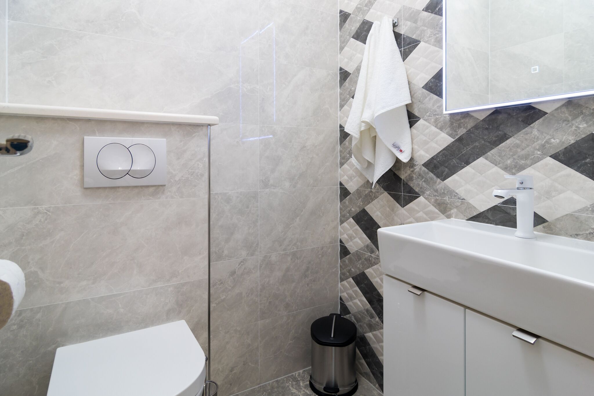 Une salle de bain comprenant des toilettes, un lavabo et un espace douche.