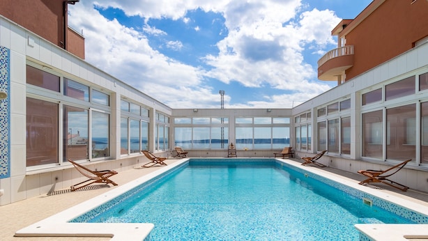 A pool area with clear blue water, sun loungers, and large windows offering ocean views. - Villa My Dream in Kastel Stari (Kastela)