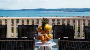 A table with a fruit basket on a balcony overlooking a body of water. - Villa My Dream in Kastel Stari (Kastela)