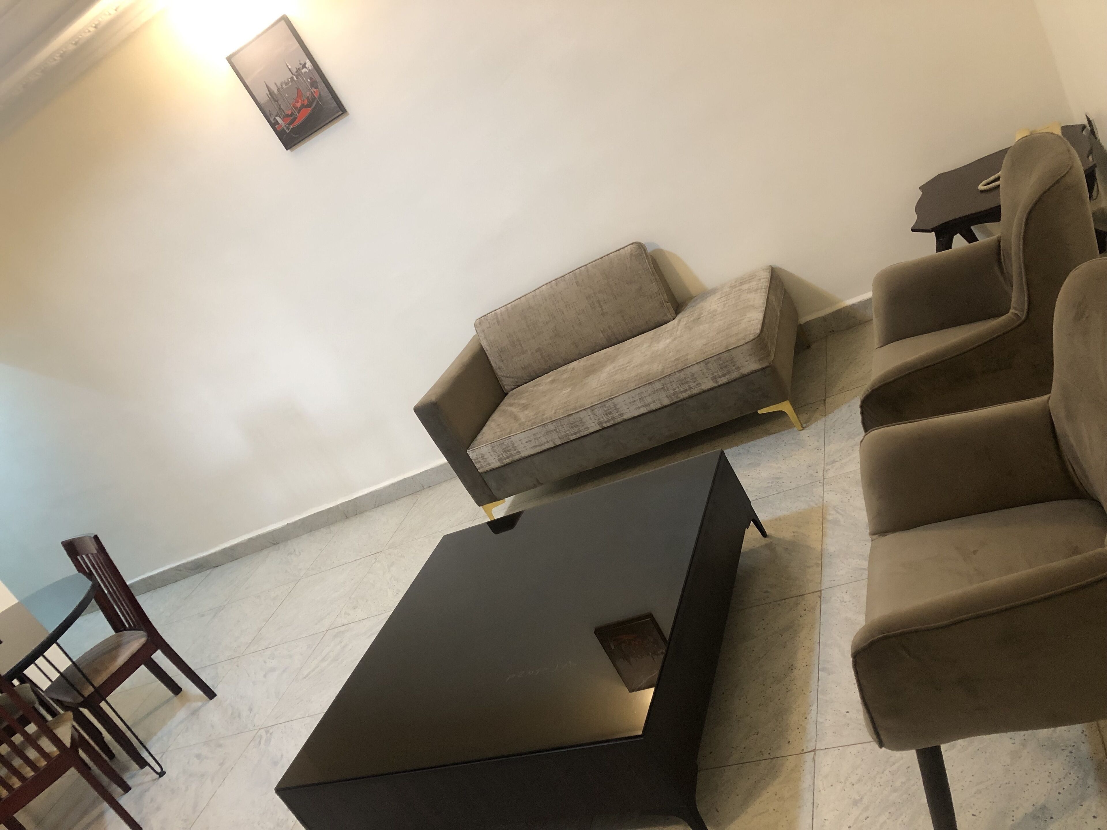 Ein modernes Wohnzimmer mit Sofa, Sessel und Couchtisch.