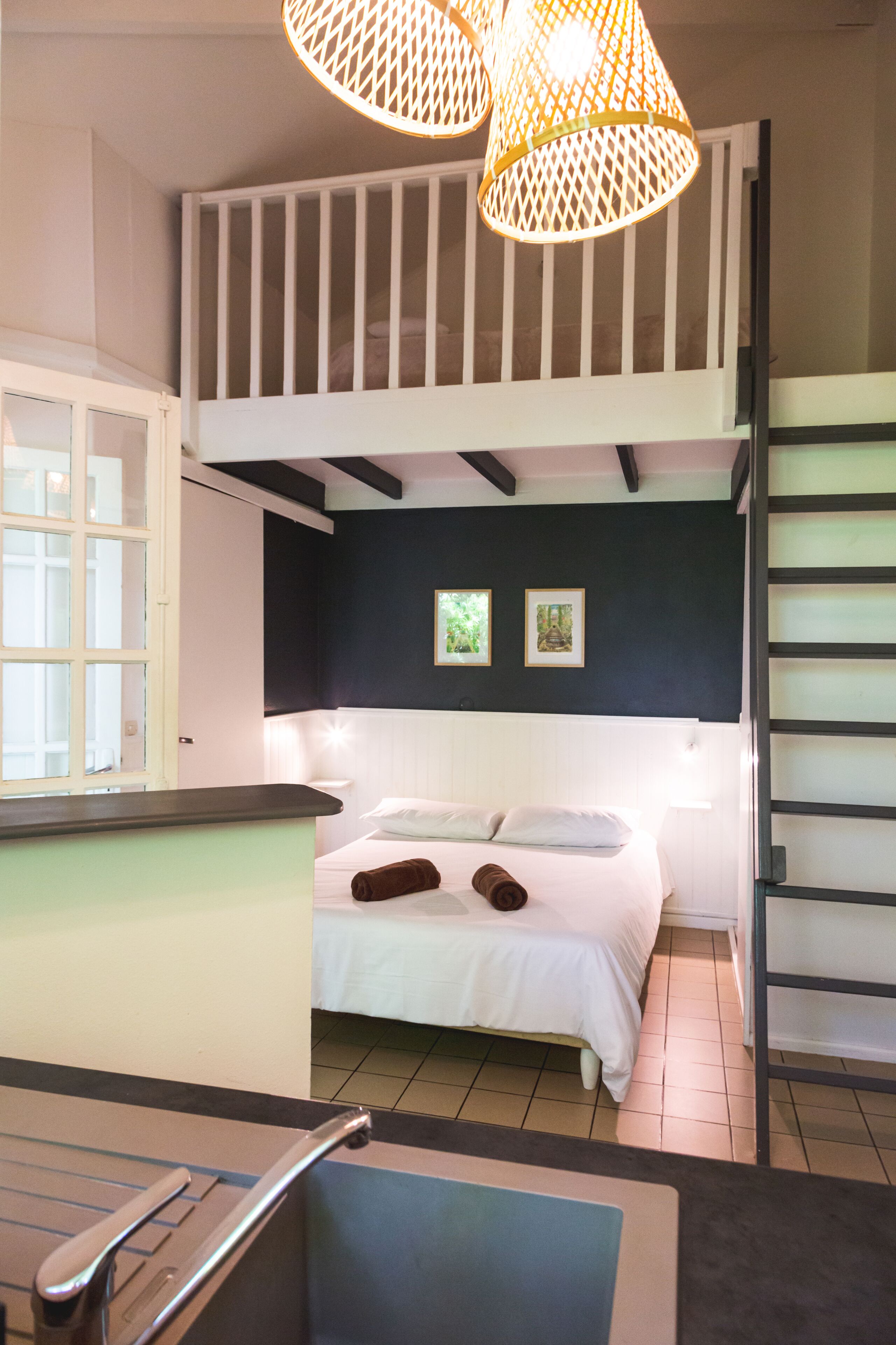 Een kamer met een stapelbed, een bureau en een stoel.