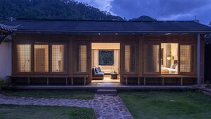 A traditional Japanese-style house with a wooden exterior and a stone pathway leading to the entrance. - Shujiawuxiangluoguqingtubuminsu (Nujiang Lisu)