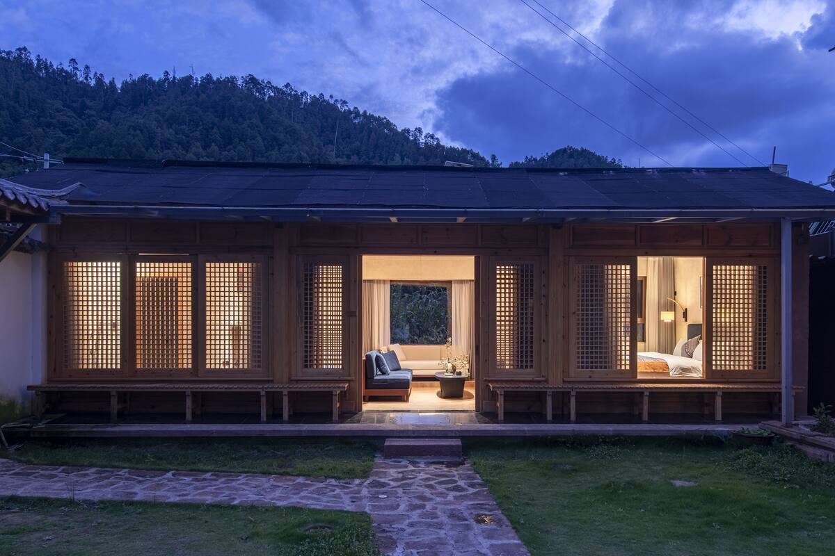 A traditional Japanese-style house with a wooden exterior and a stone pathway leading to the entrance.
