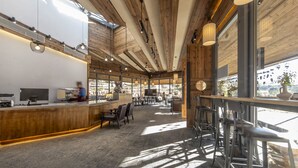 A modern interior with wooden beams, a bar area, and seating. - Shujiawuxiangluoguqingtubuminsu (Nujiang Lisu)