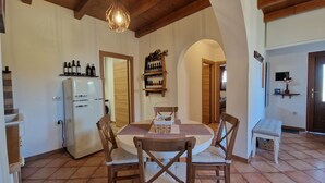 A dining area with a round table, wooden chairs, a white refrigerator, and a wine shelf. - Apartment  (Koper)
