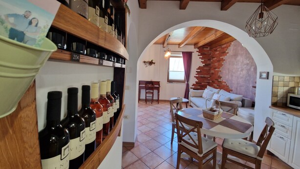 A cozy interior with a wine rack, a dining area, and a brick wall. - Apartment  (Koper)