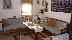 Un salon chaleureux avec un ensemble de canapés, une table basse en bois et une table à manger.