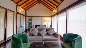 A cozy room with a sofa, two green armchairs, a coffee table, and a TV. - Lakowe Lakes Hotel Golf and Country Estate by NEWMARK (Lekki)
