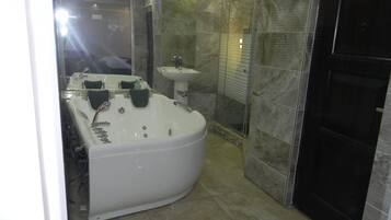 Un baño moderno con una bañera grande, un lavabo y una zona de ducha.