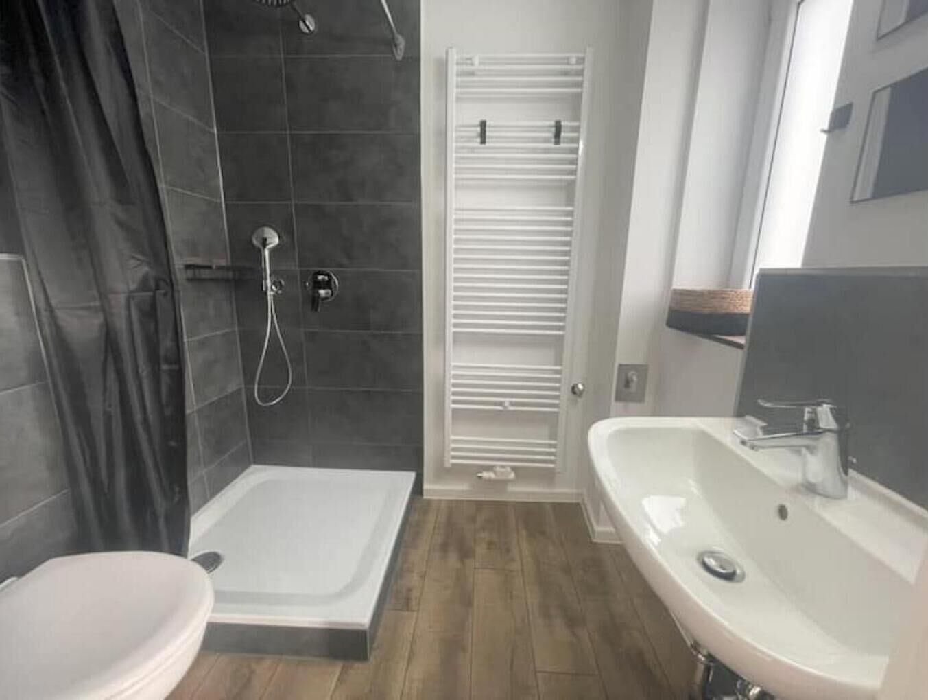 Un baño con ducha, inodoro y lavamanos.
