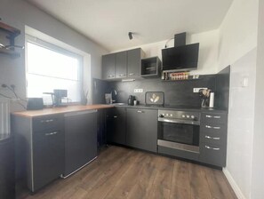 Réfrigérateur, un four, surface de cuisson, lave-vaisselle