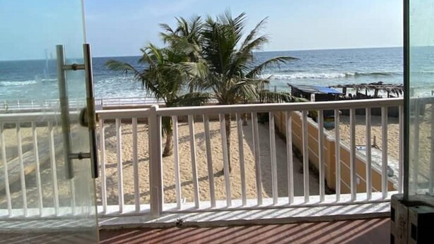 Ein Balkon mit Blick auf Strand und Meer.