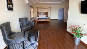 Ein Schlafzimmer mit Bett, Sofa, einem kleinen Tisch und einer Topfpflanze.