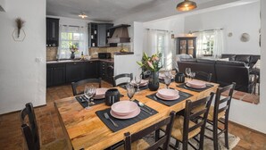 Un coin repas avec une table en bois dressée pour six personnes, entourée de chaises en bois foncé.