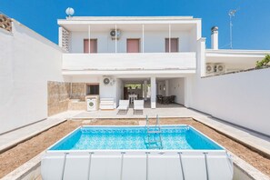 A two-story building with a swimming pool, outdoor seating, and a covered patio area. - 3461 Villa Delle Mimose by Barbarhouse (Melendugno)