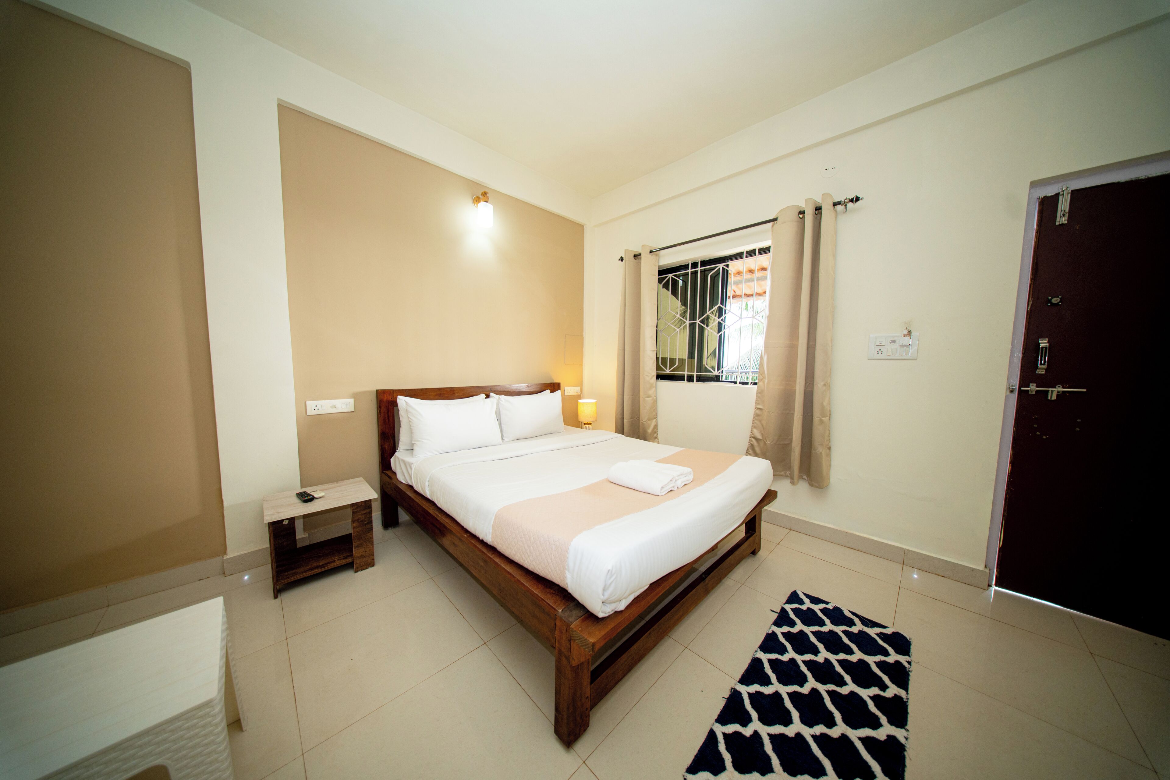 A bedroom with a bed, bedside table, and a nightstand.