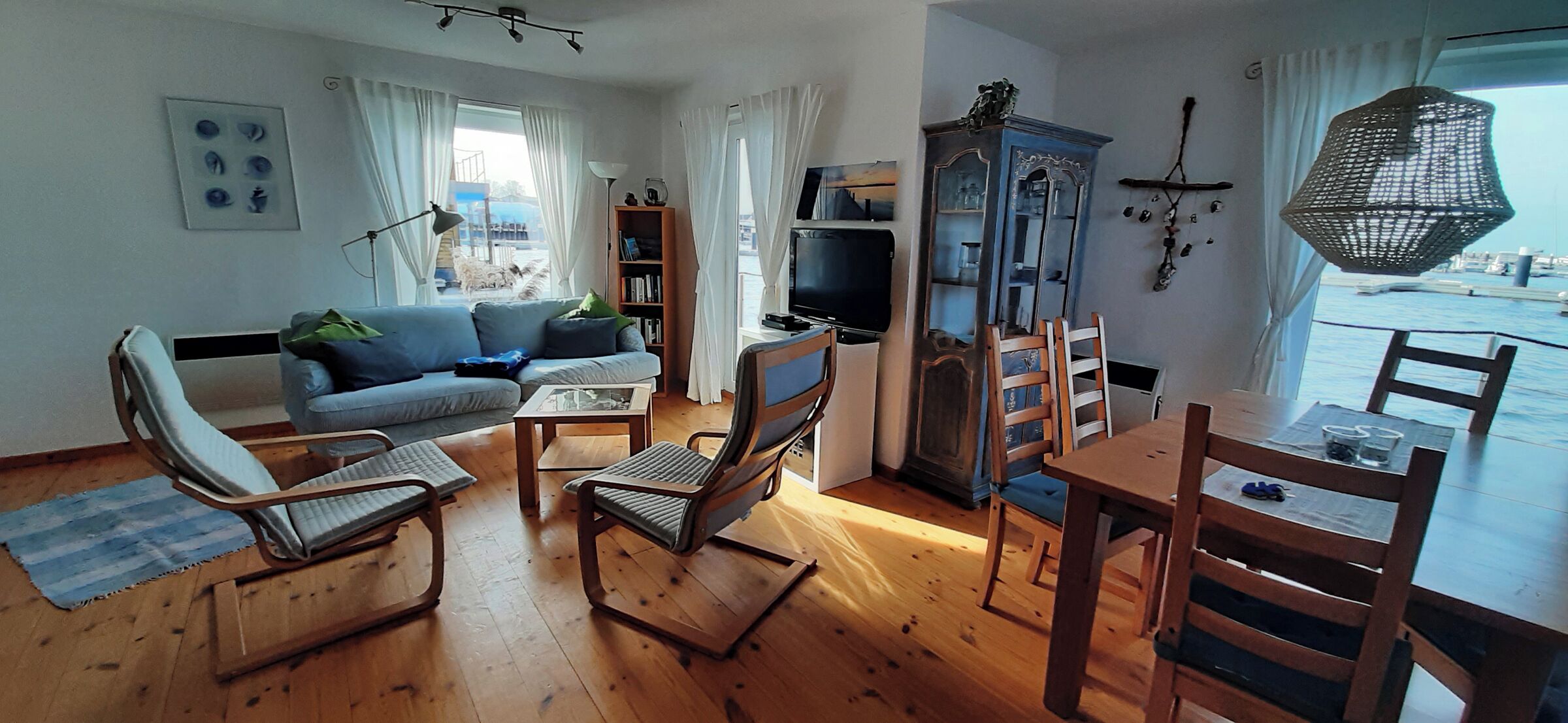 A living room with a sofa, chairs, a TV, and a dining table.