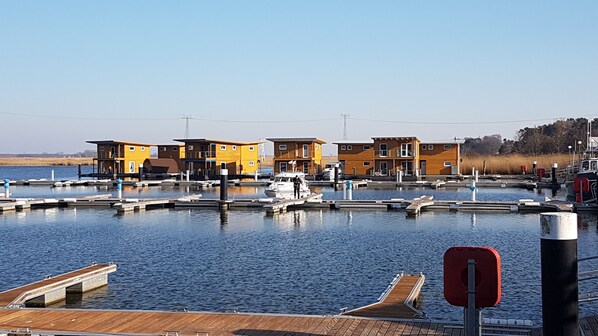 A marina with wooden docks and yellow buildings.