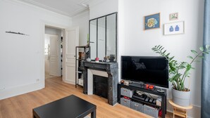 Una sala de estar moderna con chimenea, televisor y una planta en maceta.