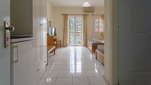 A hotel room with a bed, a TV, a desk, and a window with curtains. - Laganas Holidays Hotel (Zakynthos)